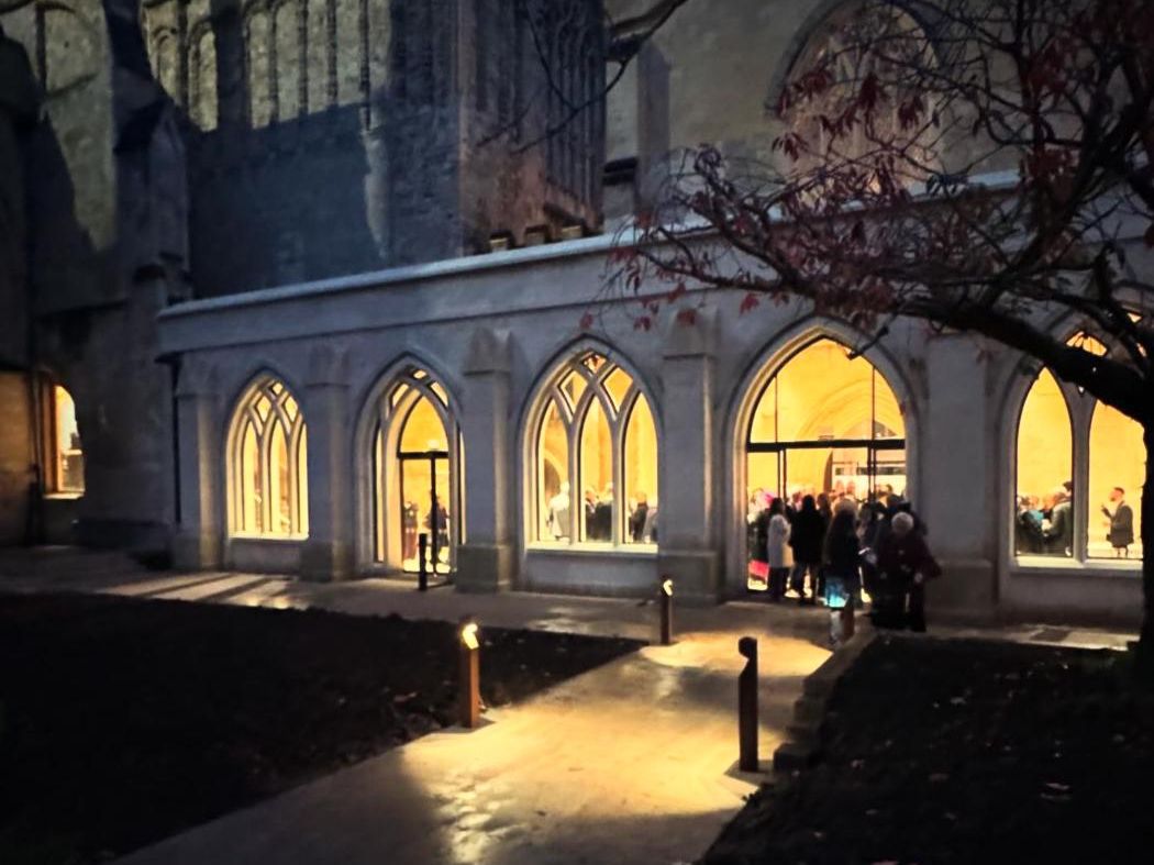 The new Friends’ Cloisters Gallery lit at dusk beside Exeter Cathedral