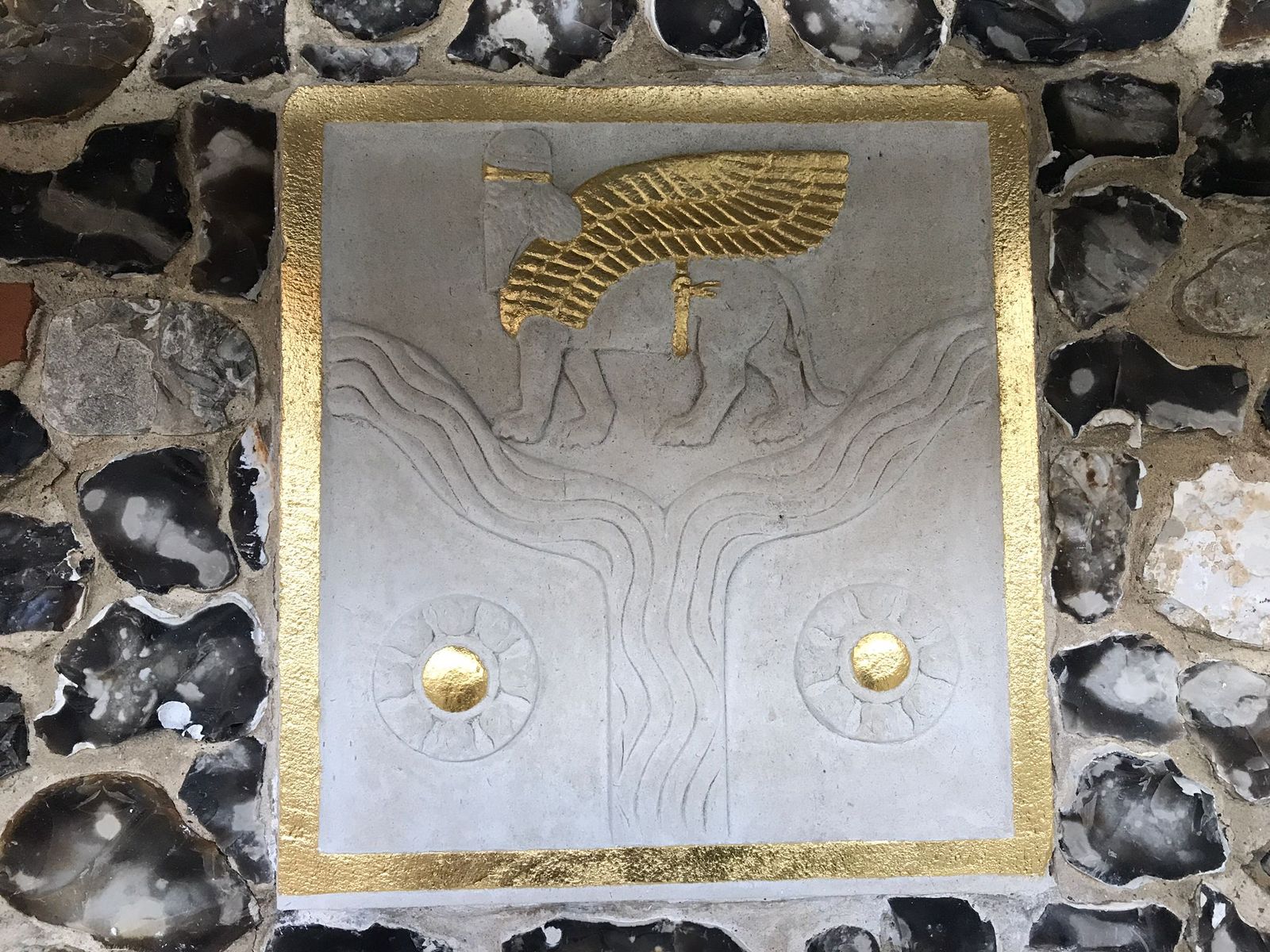 Regilded carved emblem panel set in flint, Winchester College War Cloister